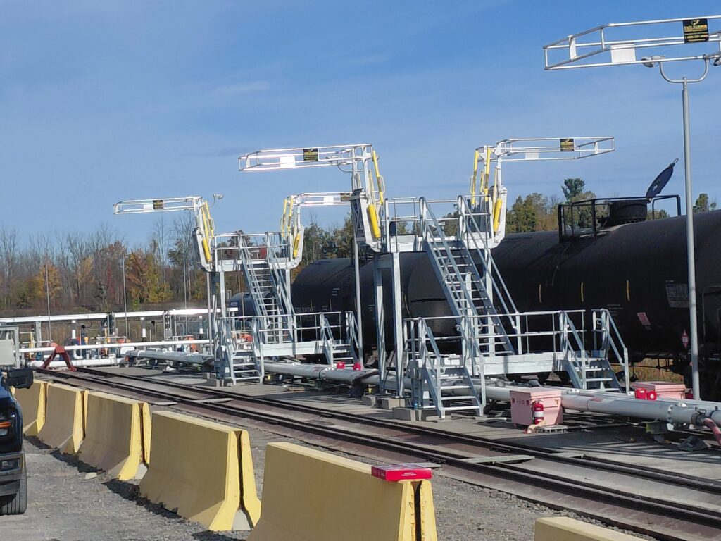 Completed 12-spot railcar unloading platforms with integrated fall protection and top-access systems for high-volume fuel transfer.