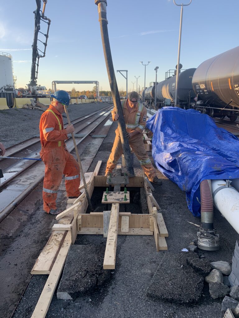 Precision civil work installing new concrete footings in constrained areas while protecting active underground pipelines.